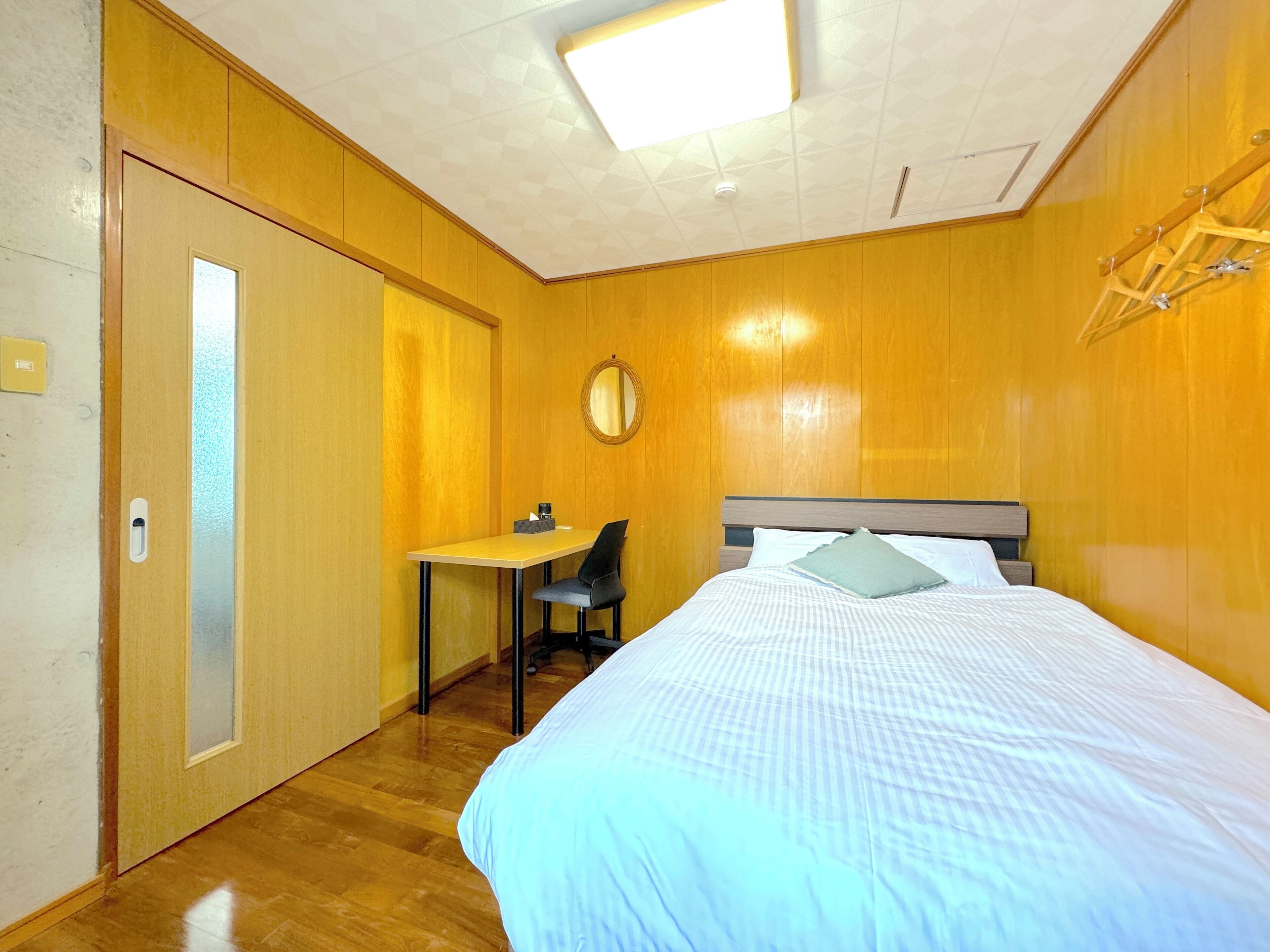 A hotel room with a bed, a desk, and a chair.