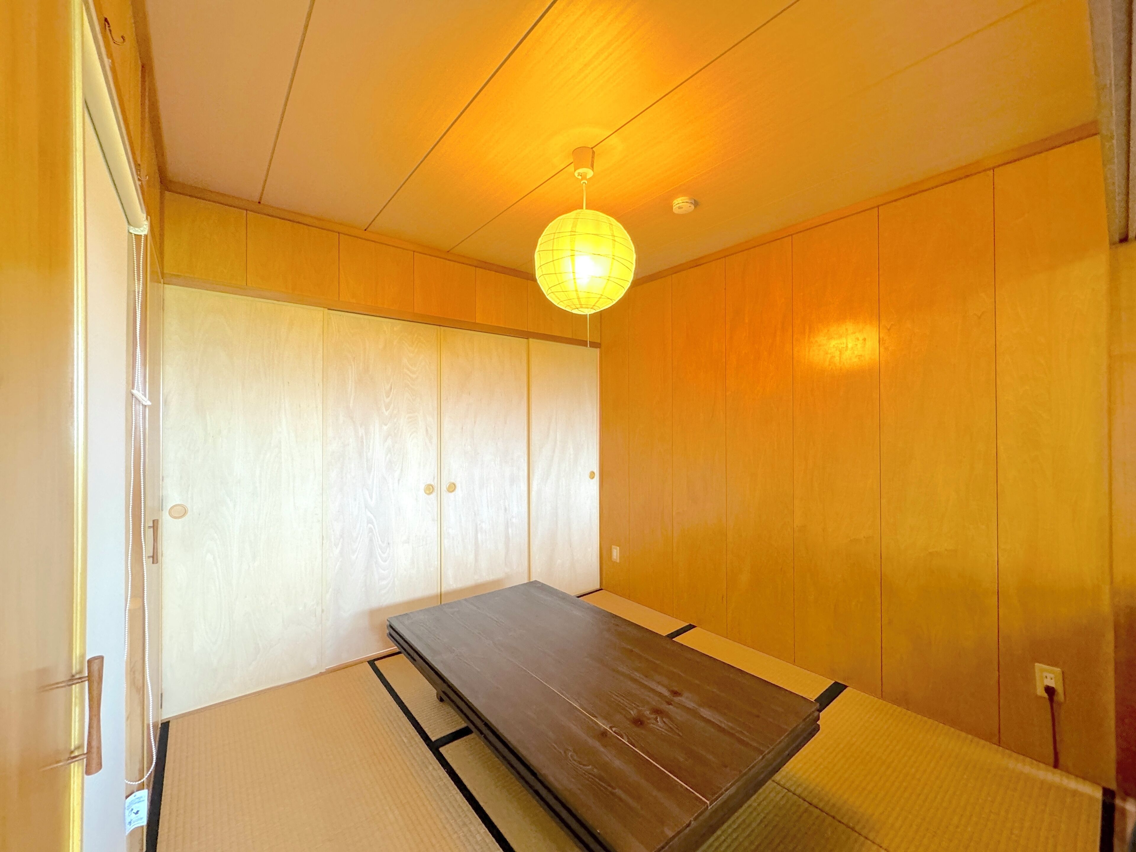 Een traditionele Japanse kamer met tatami vloerbedekking, een lage houten tafel en schuifdeuren.