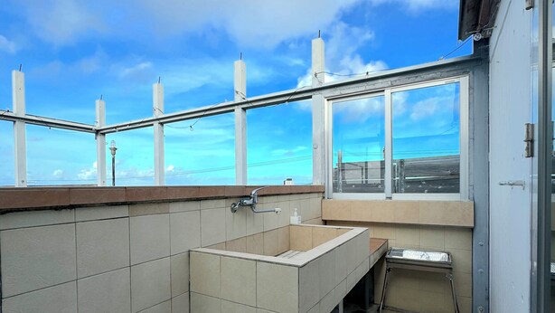 Um banheiro pequeno com azulejos e uma janela com vista para a água.