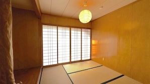 Um quarto japonês tradicional com tatames, biombos shoji e um lanterna de papel suspensa.