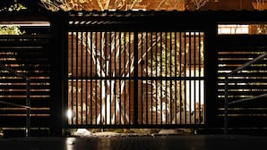 A gated entrance with vertical bars, a metal staircase on the right, and a stone pathway leading to the gate. - NIPPONIA KOSA CANAL TOWN (Kosa)