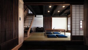 A traditional Japanese room with tatami flooring, a low table with cushions, and a sliding door. - NIPPONIA KOSA CANAL TOWN (Kosa)