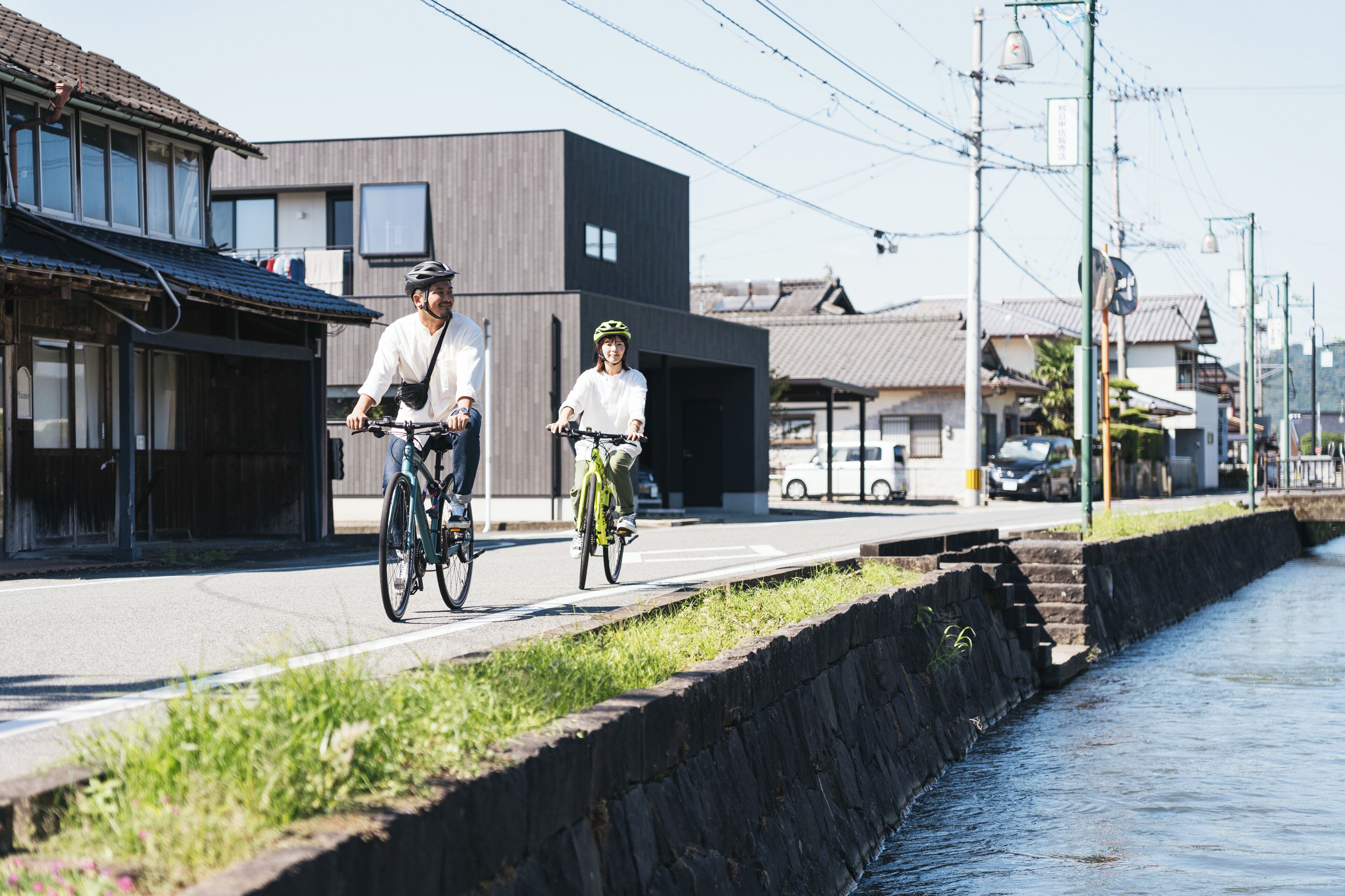 A canal-side path with a stone wall and buildings in the background.