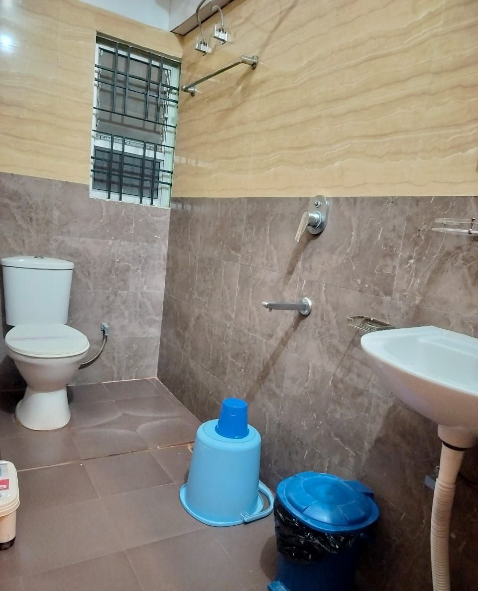 A bathroom with a toilet, sink, and shower area.