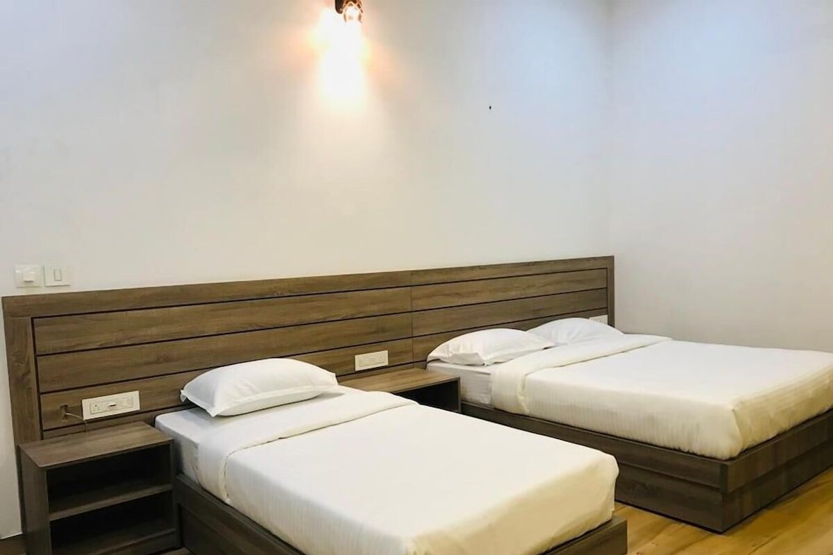 A room with two beds, wooden headboards, and bedside tables.