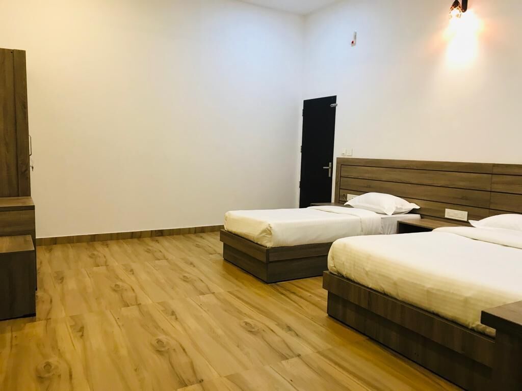 Una habitación con dos camas, un armario y una puerta.