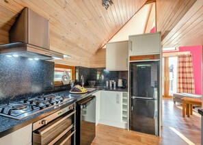A kitchen with a gas stove, oven, and a refrigerator. - Mabie Valley Lodge Pet (Dumfries, Dumfries & Galloway)