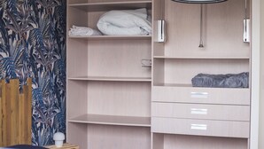 Ein Schlafzimmer mit Kleiderschrank, Bett und Nachttisch.