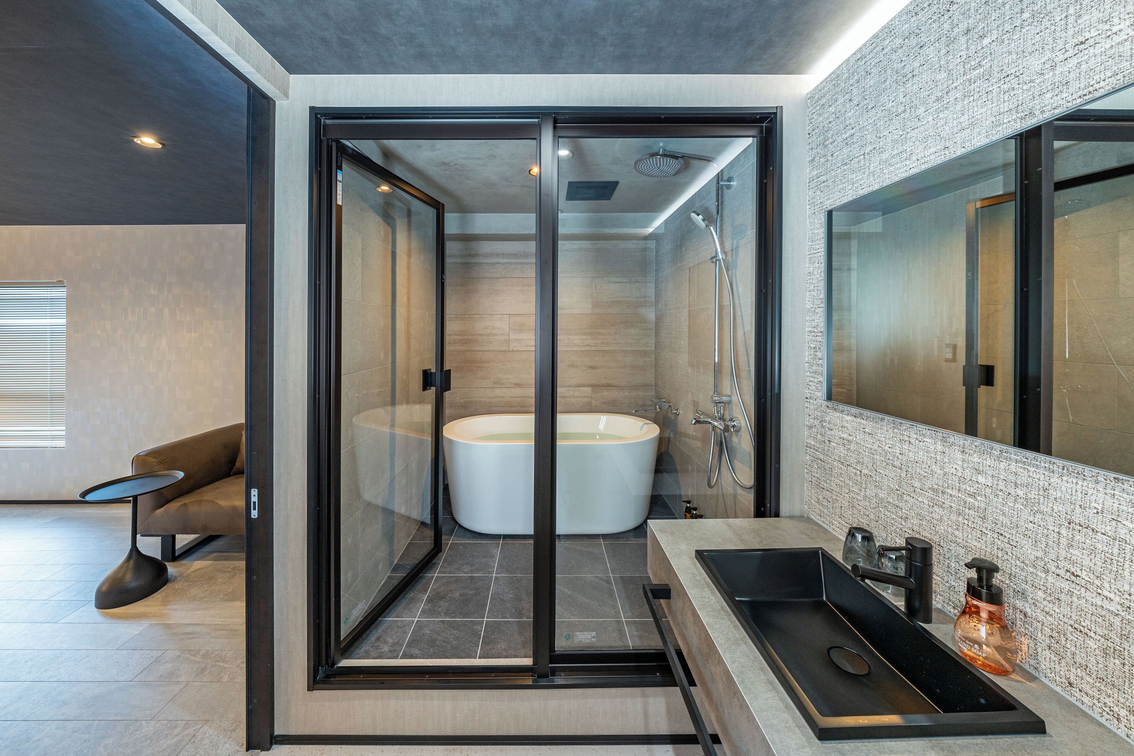 A modern bathroom with a freestanding bathtub, a glass-enclosed shower, and a large mirror.