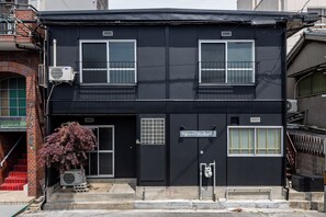 Radiant building with a central entrance and two upper-floor windows.
