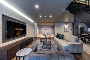 Relax in this stylish living room with a flat-screen TV, comfortable sofa, and dining area.