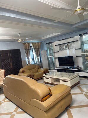 A living room with a sofa, coffee table, and TV. - CRL Apartment 2 (Ashaiman)