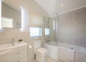 Ein modernes Badezimmer mit Toilette, Waschbecken und Duschbereich.