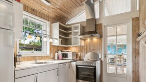 A modern kitchen with white cabinets, stainless steel appliances, and wooden accents.