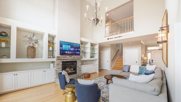 A spacious living room with a fireplace, a television, and a staircase leading to an upper level. - 2 Blocks to ocean, steps to beach, ocean view,  coastal trail, BBQ (Half Moon bay)