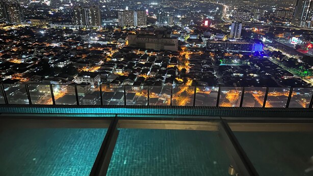 Vista panorámica de un paisaje urbano de noche, tomada desde un punto alto, probablemente un balcón de hotel.