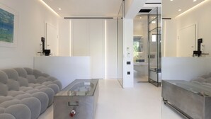 Ein modernes Wohnzimmer mit einer Couch, einem Glastisch und einem minimalistischen Design.