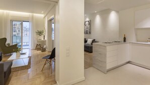 A modern apartment with a living room, dining area, and kitchen.