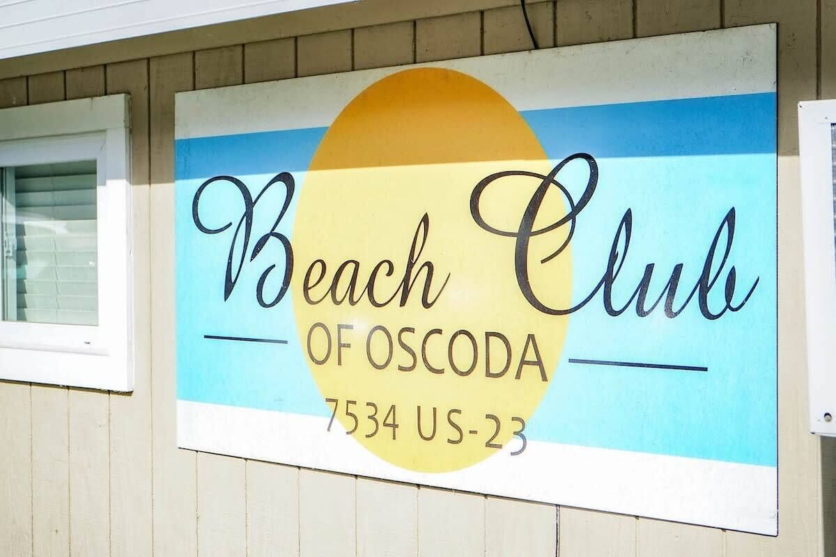 Segnale per il 'Beach Club of Oscoda' con il numero di telefono '7534 US-23'.