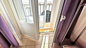 A narrow corridor with a sliding glass door leading to a balcony.
