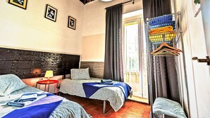 A room with two beds, a red lamp, a wall-mounted picture, and a window with curtains. - Milagros #3, three-bedroom Central Apartment (El Puerto de Santa María)