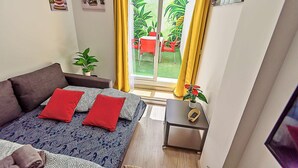 A bedroom with a bed, a small table, and a potted plant. - Plaza Herrería Central Apartment "D" with Terrace. Right downtown, best location (El Puerto de Santa María)