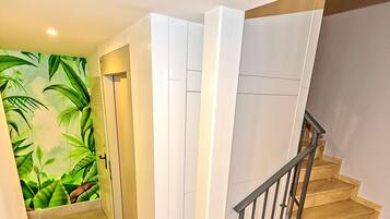 Un escalier avec une rampe en bois et une plante au rez-de-chaussée.