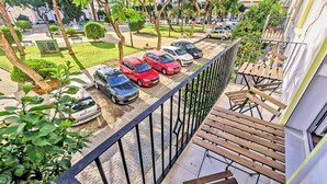 A balcony with a view of a parking area and a building with a modern design. - Plaza Polvorista 4-Bedroom Apartment with Balcony in front of the beautiful park (El Puerto de Santa María)