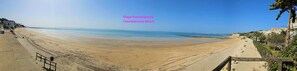 A wide, sandy beach with a clear sky. Text indicates 'Playa Fuentebravía, Fuentebravía Beach'.