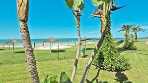 Un resort tropical con palmeras, piscina y vista al océano.