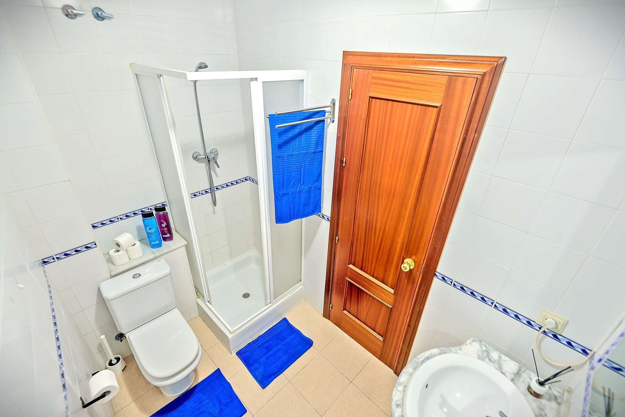 Un baño con ducha, inodoro y lavabo.