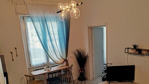 A dining area with a table, chairs, and a TV on a stand. - Brand new renovated apartment "The Dormouse" 10 minutes from the historic center (Firenze)