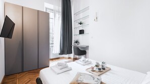 Een moderne slaapkamer met een bed, nachtkastje en een bureau.