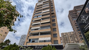A high-rise building with multiple balconies, a sign for "Piano" restaurant, and a sign for "La Vie en Rose" restaurant. - FLORIDA sea view apartment (Benidorm)