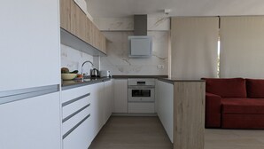 A modern kitchen with white cabinets, a wooden countertop, and a built-in oven. - ESMERALDA sea front apartment (Benidorm)