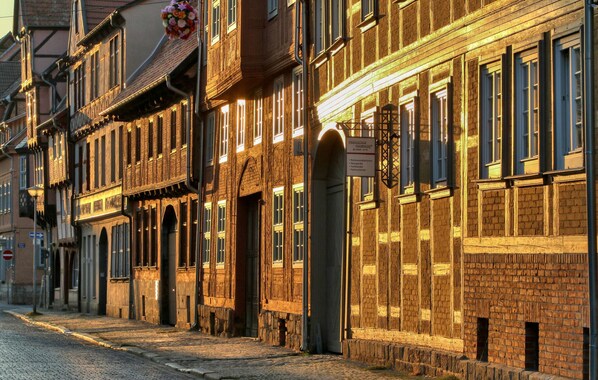 A cobblestone street lined with historic buildings featuring timber framing and brick facades.