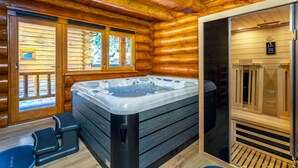 Et interiør af en hytte med jacuzzi, trægulve og sauna.