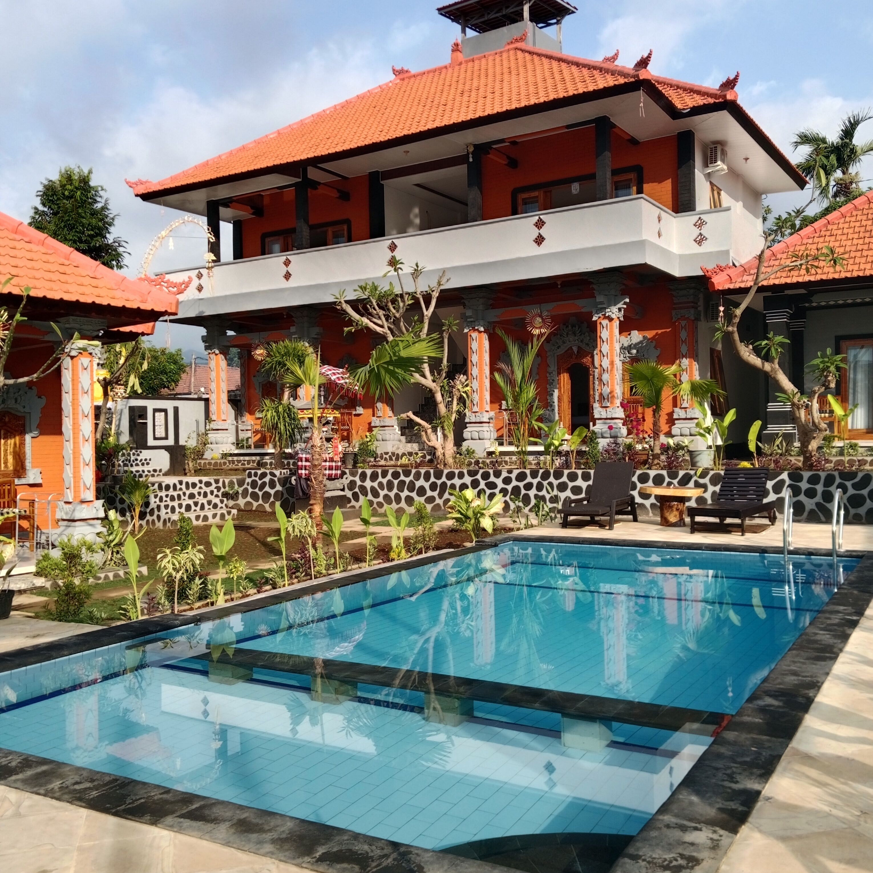 Una piscina al aire libre, sillones reclinables de piscina