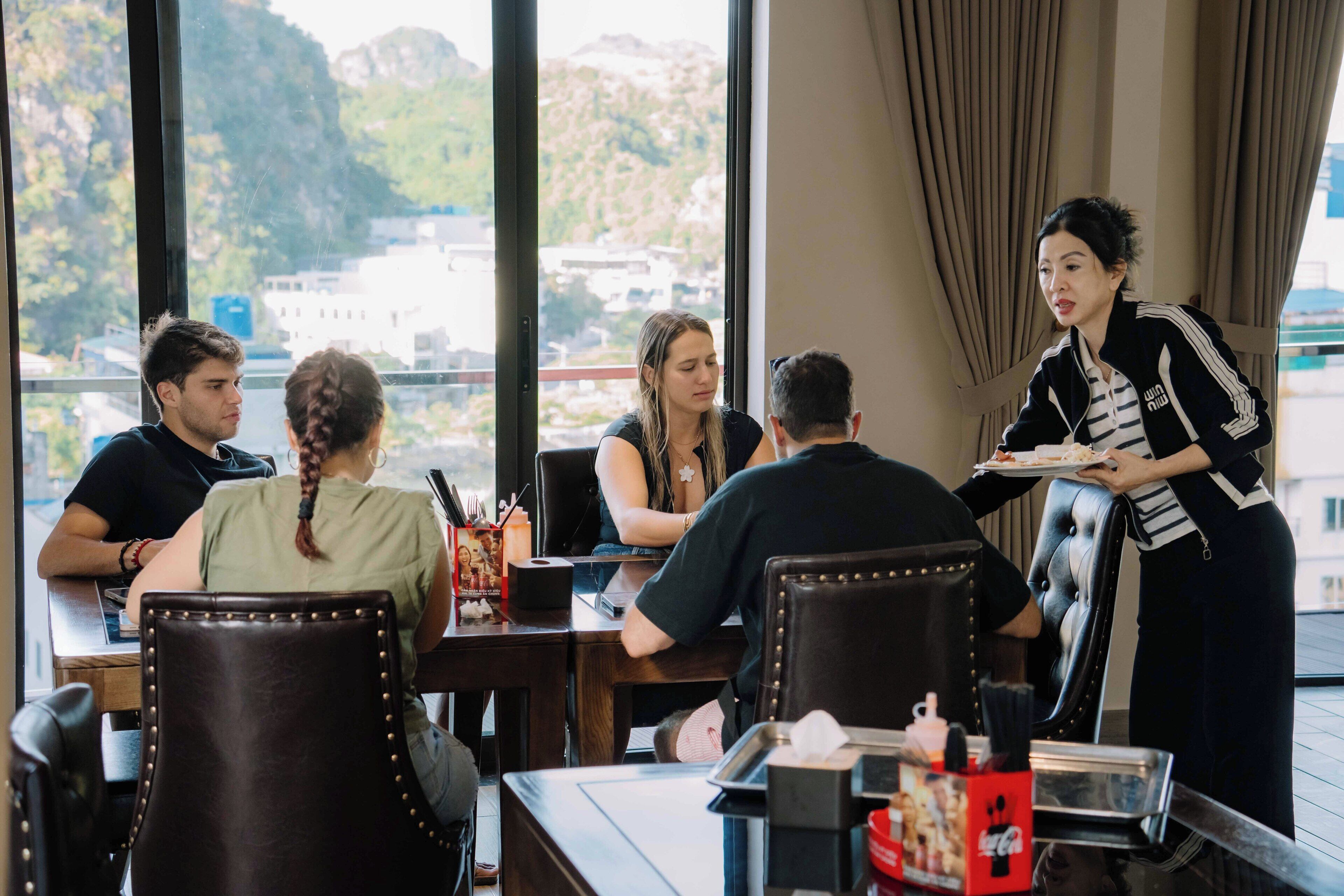 Un restaurant offrant une vue sur un paysage montagneux grâce à de grandes fenêtres.