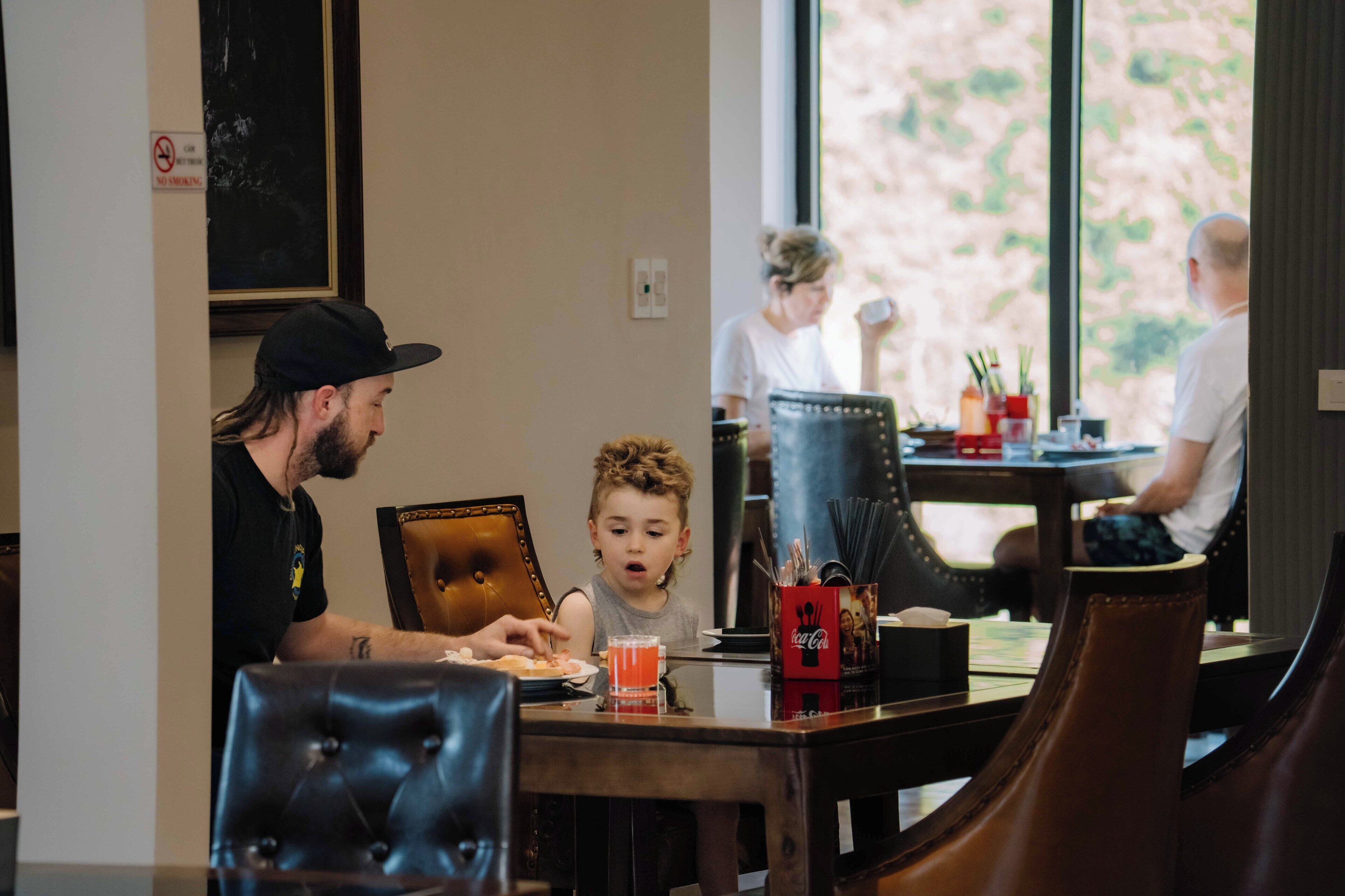 A dining area with leather chairs, a table with a glass of juice, and a Coca-Cola branded mug.