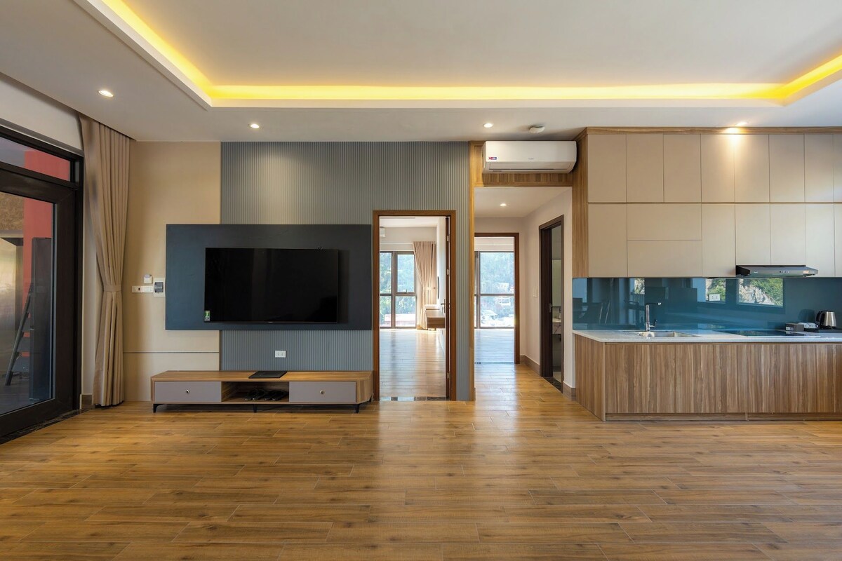 Een moderne keuken met een inbouwkookeiland, een flatscreen televisie en een eethoek met uitzicht.
