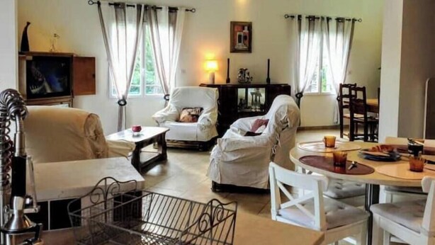 A cozy living room with a sofa, armchairs, a dining table, and a television. - Villa la Patachou à 2 pas du Village de Malaucène (Malaucène)
