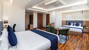 Ein Hotelzimmer mit einem großen Bett, einem Schreibtisch, einem Stuhl und einer separaten Sitzecke mit einer Couch.