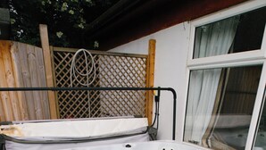 A hot tub with a wooden deck surrounding it. - EBS London Stay (London)