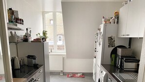 Una cucina moderna con isola centrale, forno integrato, lavatrice e tostapane.