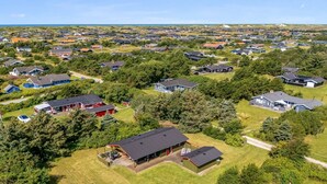 Luchtbeeld van een woonwijk met huizen, groene gazons en een vlag.