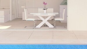 A modern indoor pool area with a white pool table and chairs, a potted plant, and a tiled floor. - Villa With Swimming Pool (Matulji)