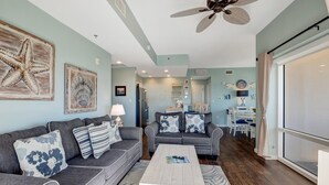 A living room with a grey sofa, a white coffee table, and a ceiling fan. - Serene Gulf Views: 2-Bedroom 2-Bathroom Retreat at Luau, Panoramic Gulf Views at Sandestin Golf and Beach Resort! (Miramar Beach)