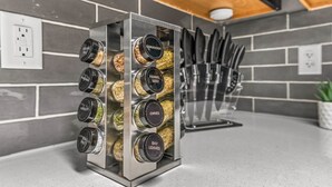 A spice rack with labeled containers of various spices.