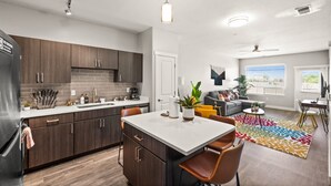 Una cocina moderna con armarios de madera oscura, una encimera blanca y una isla central.